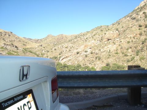 1997 Ford Probe - A white Honda is parked near a guardrail with a mountainous landscape in the background.