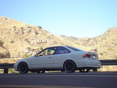 1997 Ford Probe - A white Honda Civic coupe is parked on the side of a road with a mountainous landscape behind it.