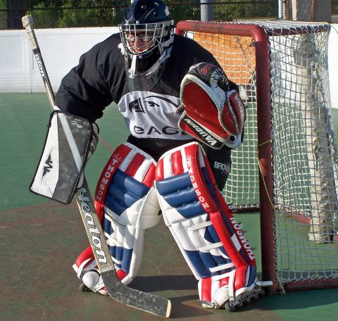 1973 Ford Ranchero - A hockey goalie stands ready in front of a net, equipped with protective gear and a stick.