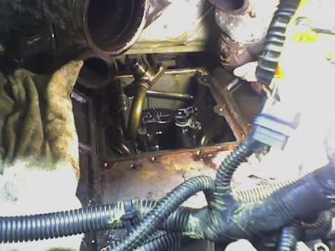 1992 Ford Bronco - Mechanic working on an engine, with visible valve train components and various hoses.