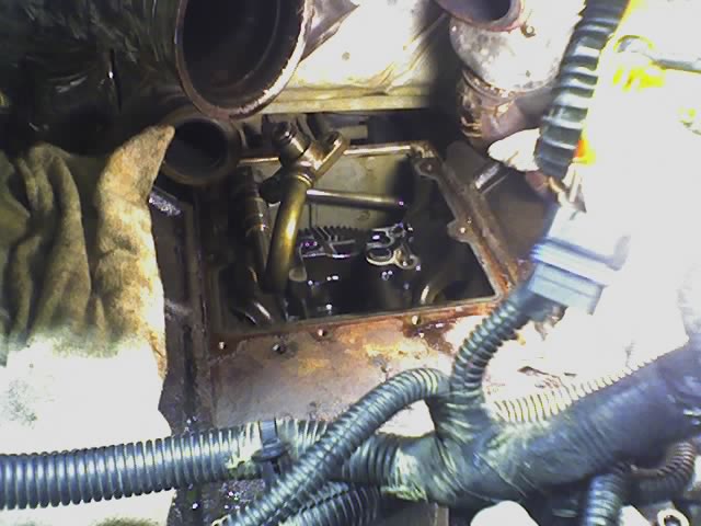 Close-up of engine internals during repair, showing valve train and plumbing