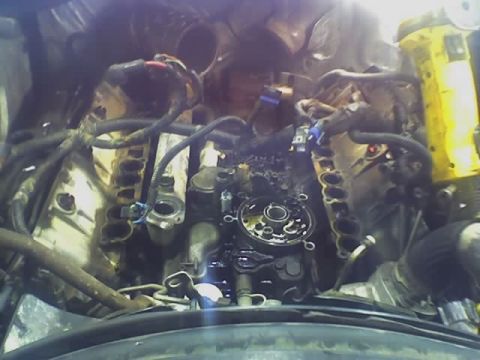 1992 Ford Bronco - The engine bay shows disassembled components and wiring, with a yellow tool in the background.