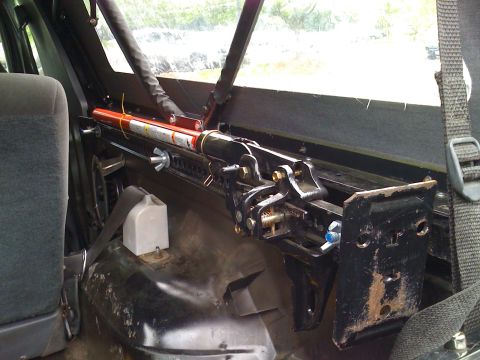 1993 Ford Bronco - A Hi-Lift jack is mounted inside a vehicle's interior, secured to a metal bracket.