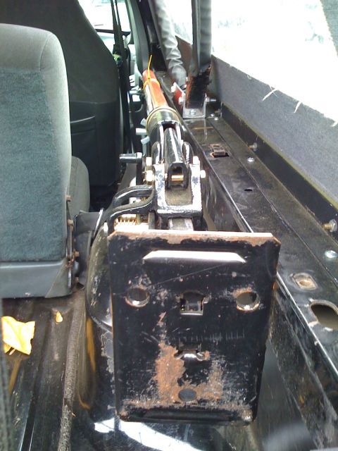 1993 Ford Bronco - A Hi-Lift jack is mounted inside the rear cargo area of a vehicle, next to the rear seat.