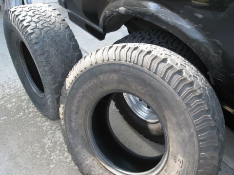 1986 Ford Bronco - Close-up of off-road tires next to a vehicle's fender.