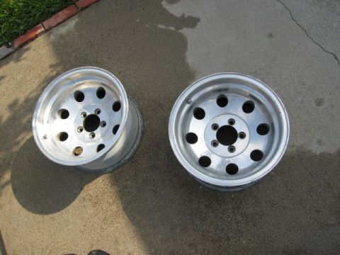 1986 Ford Bronco - A pair of aluminum alloy wheels are displayed on a concrete surface, likely for sale or identification.