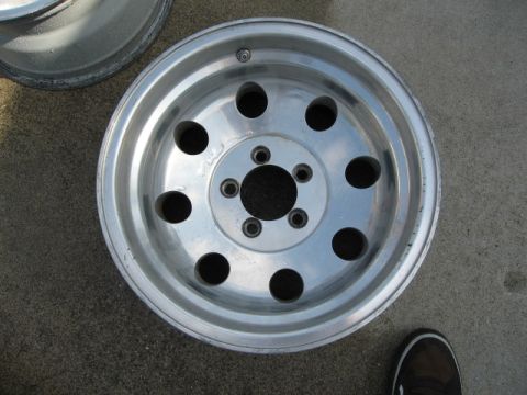 1986 Ford Bronco - Close-up of an aluminum alloy wheel with multiple circular cutouts.