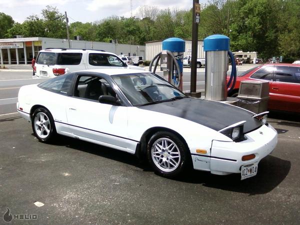 White 1991 Nissan 240SX with black hood and roof, parked at a gas station
