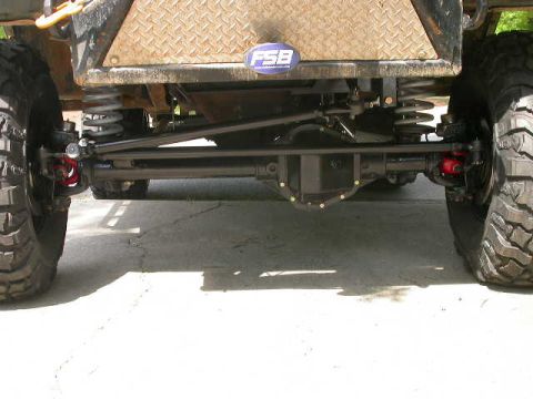 1990 Ford Bronco - Close-up view of the suspension and drivetrain components of a modified off-road vehicle.