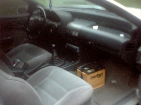 1989 Ford Probe - Interior view of a car, front seats and a battery on the passenger side floor.