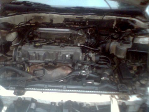 1989 Ford Probe - The engine compartment of a car is shown, with various mechanical components and wiring.