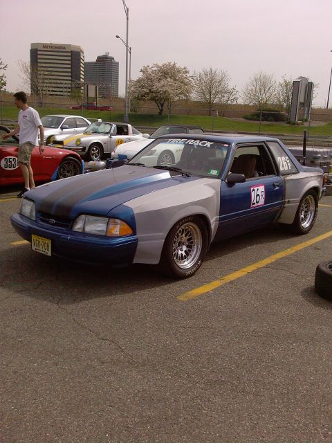 2001 Mercury Grand Marquis - A modified coupe with racing numbers and stickers sits in a parking lot next to other vehicles.