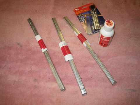 1987 Suzuki Samurai - Supplies for body work, including metal rods, cleaner, and brushes, are laid out on a textured surface.