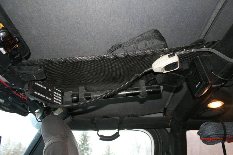 Overhead console with CB radio, flashlight, and microphone in a vehicle interior