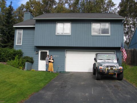 2003 Jeep TJ - A silver 2003 Jeep TJ is parked in front of a blue house with a white garage door.