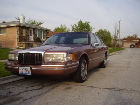 1996 Ford F-150 - This Lincoln Town Car is parked on a suburban street in front of a house.