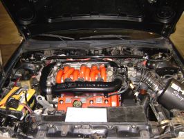 1991 Ford Taurus - The engine bay of a car is shown with the hood open, highlighting the intake manifold and air filter system.