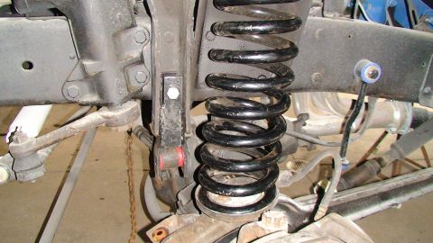 1979 Ford Bronco - This image shows the front suspension system of a vehicle, focusing on the coil spring and associated mechanical parts.