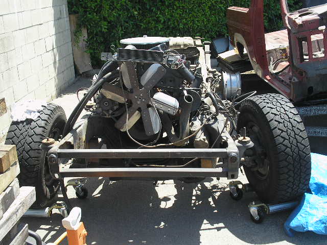 1986 Ford Bronco chassis with engine and front suspension visible. Body is partially removed