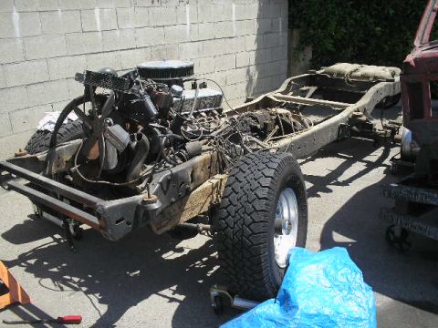 1986 Ford Bronco - The chassis and engine of a vehicle are visible, undergoing some form of work or disassembly.