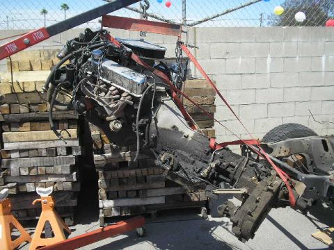 1986 Ford Bronco - Engine and transmission assembly being hoisted, likely for removal or installation.
