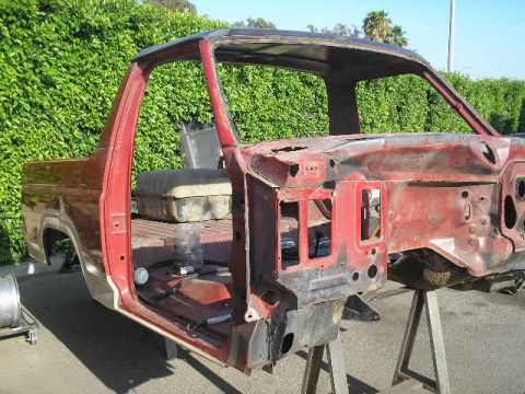 1986 Ford Bronco - The body of a 1986 Ford Bronco, stripped down and on stands, is shown from a 3/4 front angle.