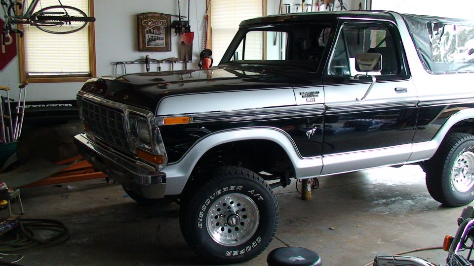 Black and silver Ford Bronco in a garage, front quarter view