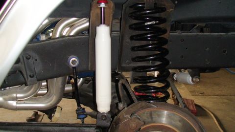 1979 Ford Bronco - Close-up view of a vehicle's suspension system, showing exhaust headers and shock absorber.