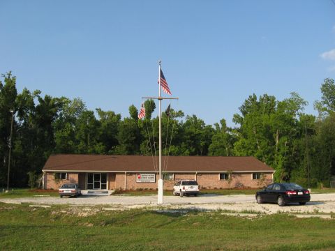 2006 Ford F-150 - A United States Coast Guard station building is seen with three vehicles parked in front under a clear blue sky.