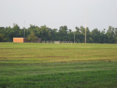 2006 Ford F-150 - A rural landscape features a brick building, a line of antennas, and a tall tower against a hazy sky.
