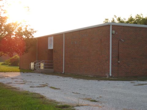 2006 Ford F-150 - A brick building with 'COMMSTA NOLA' visible on its facade, bathed in the warm light of the setting sun.