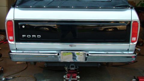 1979 Ford Bronco - The rear of a 1979 Ford Bronco, its distinctive silver and black color scheme and soft top.