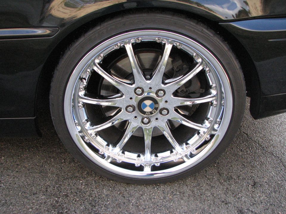 Chrome BMW wheel with a BMW logo on a black car