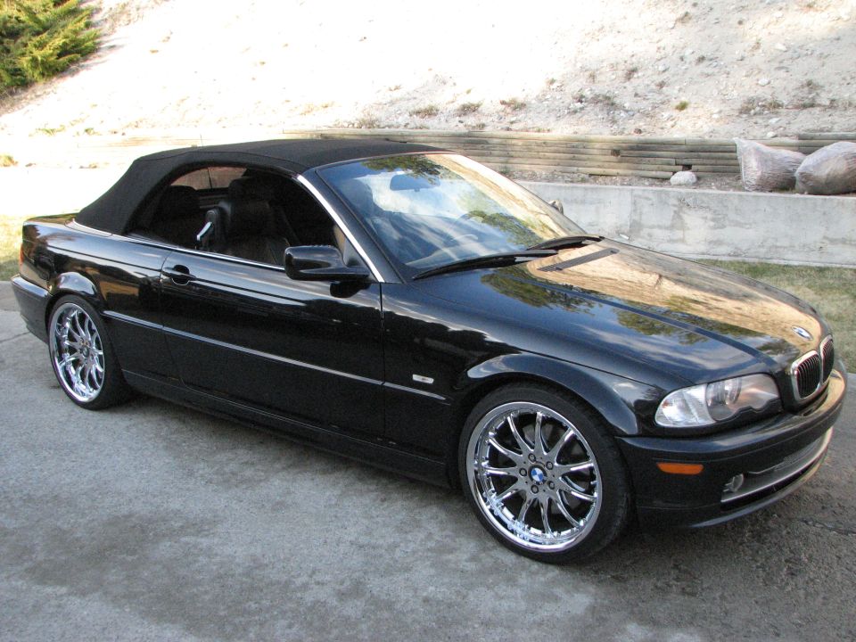Black 2002 BMW 3 Series convertible with chrome wheels parked on concrete