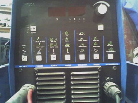 1992 Ford Bronco - Close-up of a welding machine's control panel, showing numerous buttons, knobs, and a digital readout for settings.