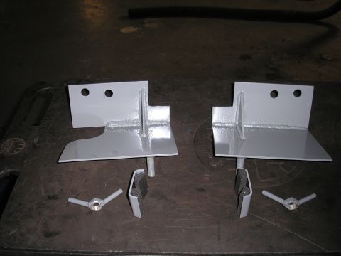 1995 Ford Bronco - Two gray hi-lift jack mounts with hardware are shown laid out on a dark surface.