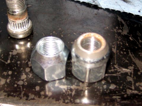 1996 Ford Bronco - Close-up view of two lug nuts and a wheel stud, likely for a vehicle's wheel assembly.