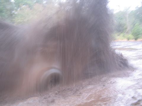 1990 Ford Bronco - A vehicle is driving through a muddy area, creating a large splash.