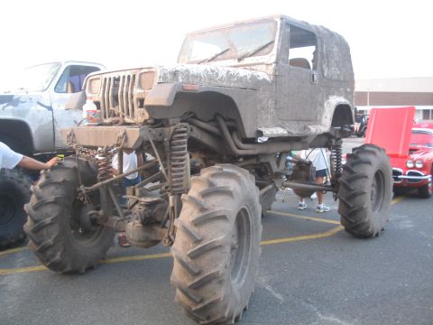 1990 Ford Bronco - This heavily modified Jeep Wrangler is equipped with massive tractor tires, suggesting it's built for off-road or mud bogging.
