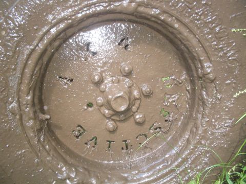 1990 Ford Bronco - Mud obscures most of the wheel and tire details, but some text is visible on the sidewall.
