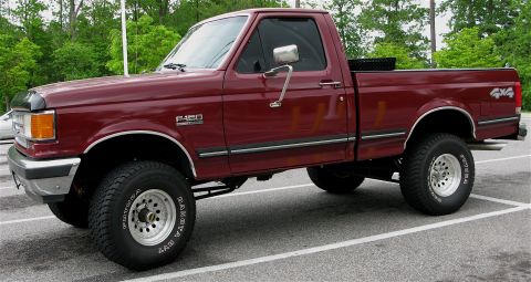 1991 Ford F-150 - This maroon 1991 Ford F-150 pickup truck is shown from a 3/4 front angle.