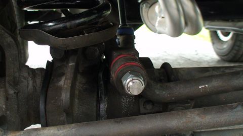 1979 Ford Bronco - Undercarriage view of a suspension component, possibly from a 1979 Ford Bronco, red bands on the linkage.