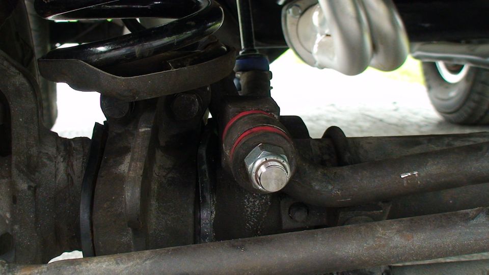 Close-up of a vehicle's suspension linkage with red bands