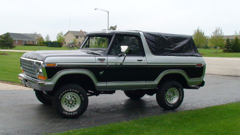 1979 Ford Bronco - Two-tone 1979 Ford Bronco parked on a driveway with a black soft top covering the rear.