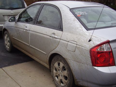 1996 Ford F-150 - The side view of a silver sedan covered in mud. A sticker on the rear window reads "PUSH ME OR PASS ME GET OUT MY ASS".