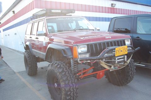 1978 Ford Bronco - Modified Jeep Cherokee XJ with off-road tires and custom bumper parked next to another vehicle.