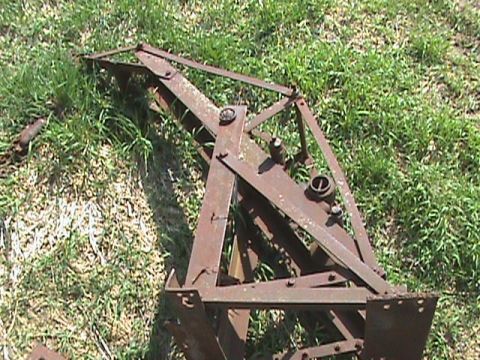 1987 Ford Bronco - This rusted metal farm equipment part is shown in a grassy area.
