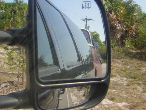 1971 Volkswagen Vanagon - A red and white van is seen reflected in the side mirror of another vehicle.