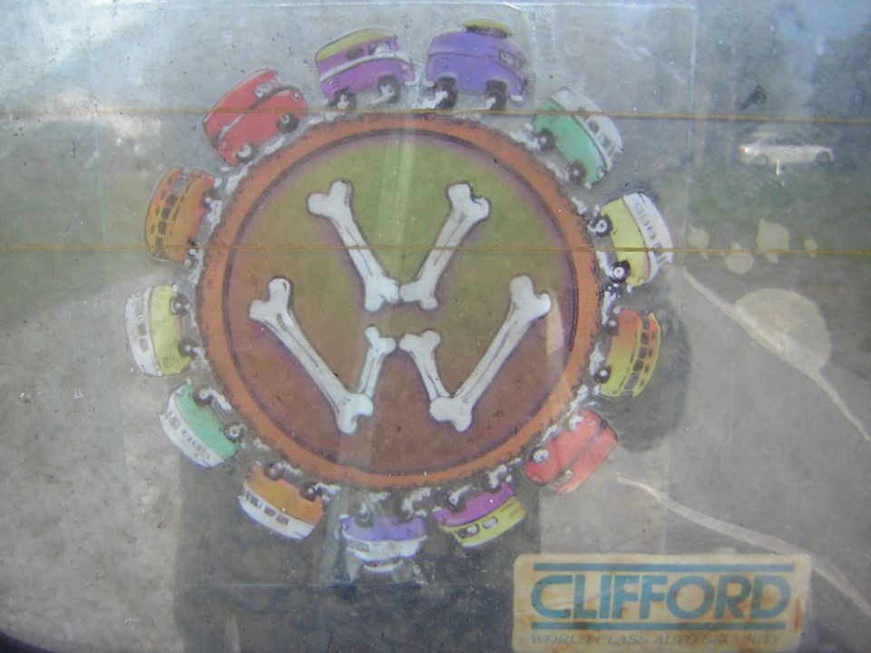 Sticker of colorful cartoon vans arranged in a circle around a VW logo made of bones