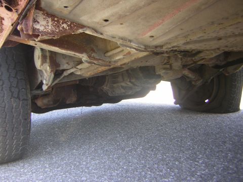 1971 Volkswagen Vanagon - The underside of a vehicle shows significant rust and wear on its chassis and mechanical parts.